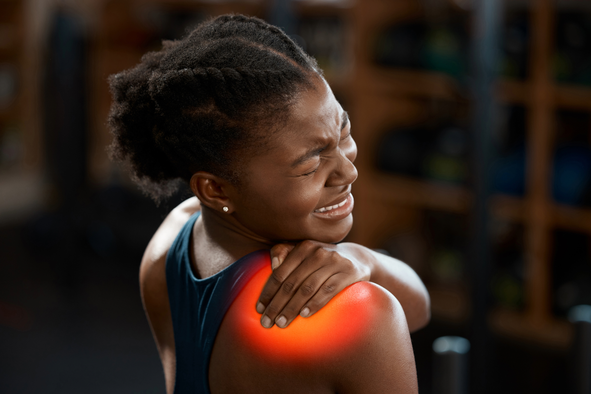 Woman holding her shoulder in pain with red highlighted area indicating inflammation
