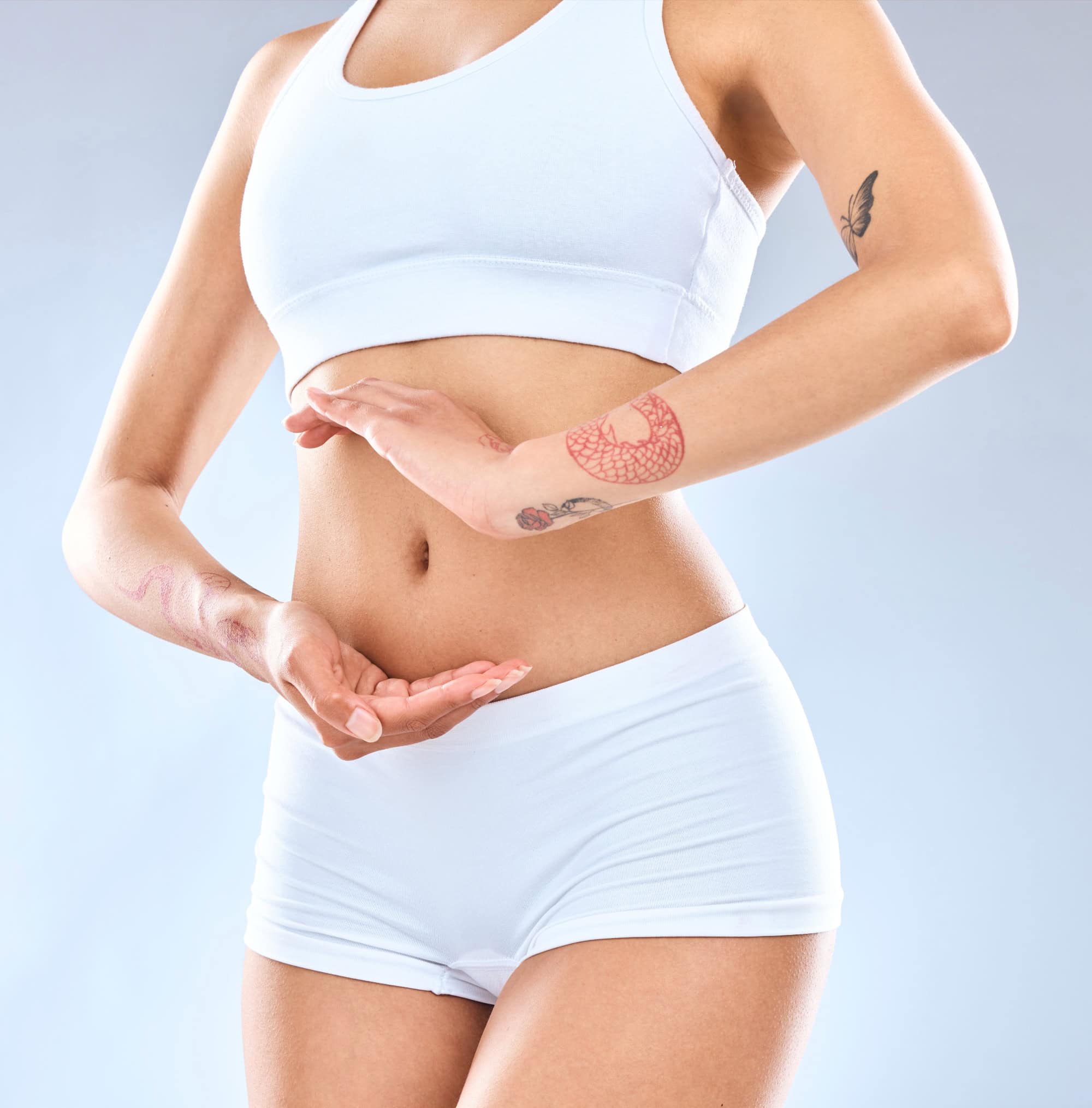 Fit woman in white underwear making a circle gesture with her hands around her toned belly