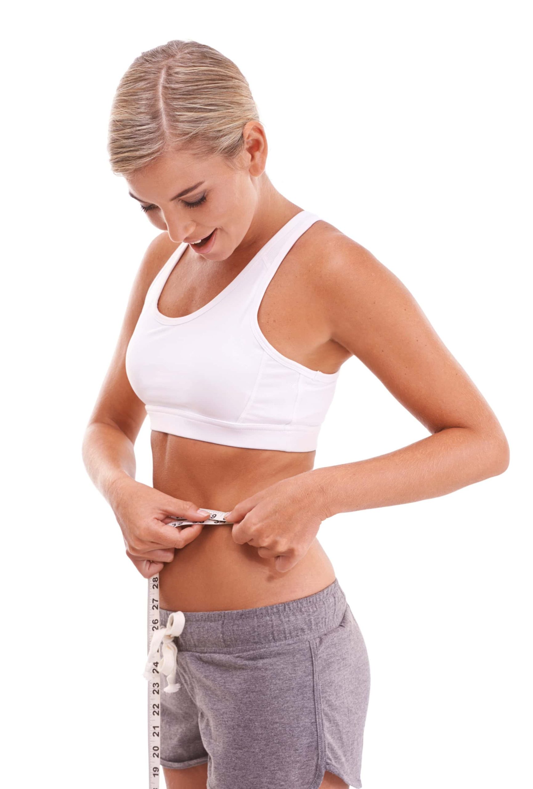 Woman in sportswear measuring her waist with a tape measure, smiling