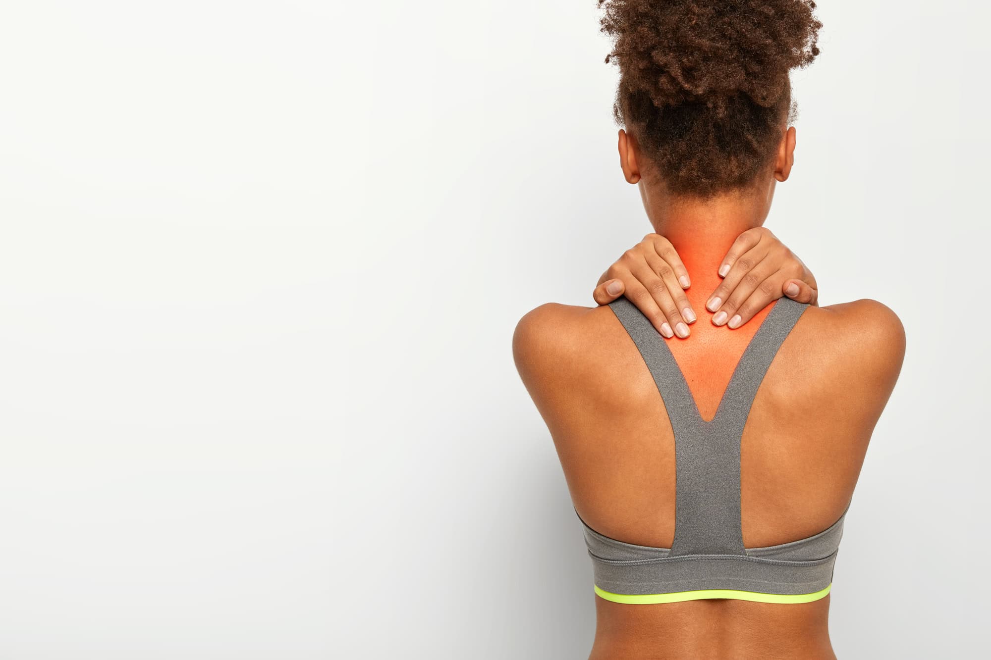 Young woman holding her painful neck with visible inflammation, seeking natural muscle recovery.